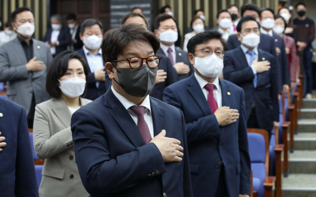 박홍근(사진 위) 더불어민주당 원내대표가 22일 '검수완박' 중재안 수용 여부를 논의하기 위해 국회에서 열린 당 의원총회장으로 향하고 있다. 이런 가운데 권성동(아래 사진) 국민의힘 원내대표도 중재안 논의를 위한 당 의총에서 국기에 대한 경례를 하고 있다. 성형주 기자