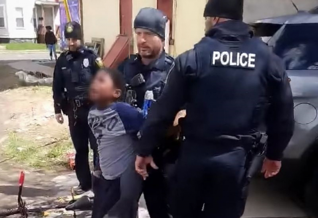 지난 19일(현지시간) 미국 뉴욕 시러큐스 경찰관들이 과자 한 봉지를 훔친 8살 흑인 소년을 강제로 경찰차에 태우고 있다. 트위터 캡처