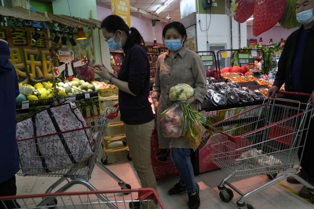 베이징 차오양구의 한 슈퍼마켓에서 25dlf 마스크를 쓴 주민들이 봉쇄 조치에 대비해 장을 보고 있다. AP연합