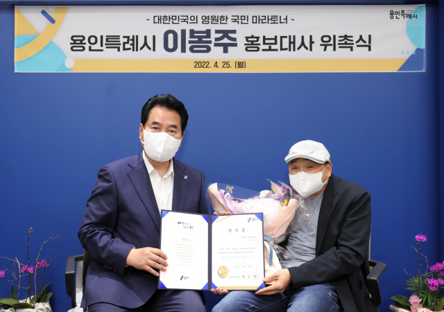 백군기(왼쪽) 용인시장이 25일 국민 마라토너 이봉주에게 홍보대사 위촉장을 전달하고 기념촬영을 하고 있다. /사진제공=용인시