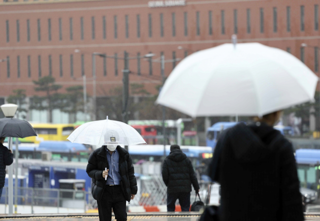 지난 3월 26일 오전 서울역 인근에서 시민들이 우산을 쓴 채 길을 걷고 있다. 연합뉴스