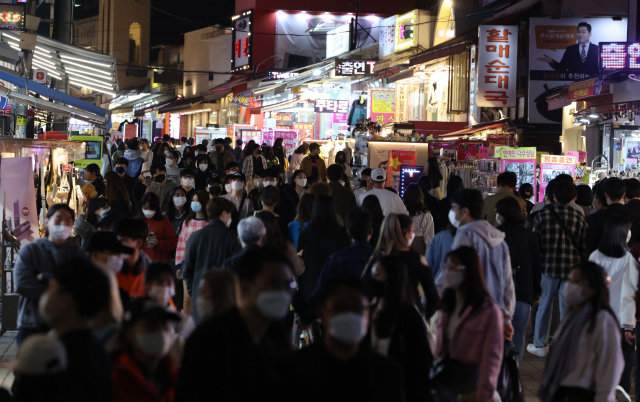 코로나19 사회적 거리두기 해제를 하루 앞둔 17일 서울 마포구 홍대입구역 인근에서 시민들이 걸어가고 있다. 연합뉴스