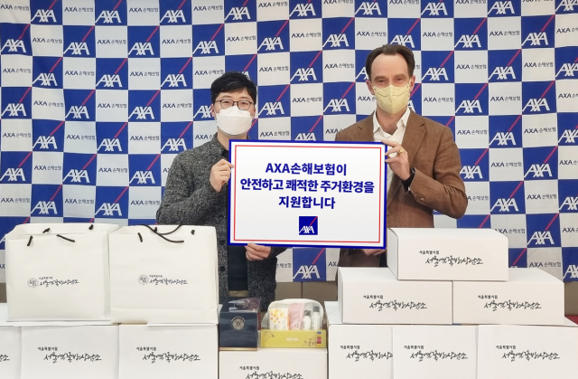 기욤 미라보(오른쪽) AXA손해보험 대표이사가 26일 서울 용산구 소재 악사손보 본사에서 이찬희 서울역쪽방상담소 팀장에게 주거취약계층 가구를 위한 물품을 전달하고 있다. 사진 제공=악사손보