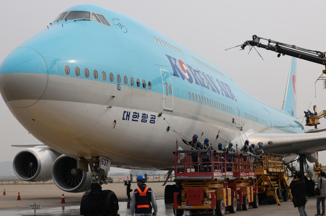 사회적 거리두기 전면 해제 첫날인 18일 오전 영종도 인천국제공항 대한항공 정비 격납고에서 관계자들이 보잉 747-8i 항공기 동체를 세척하고 있다./연합뉴스