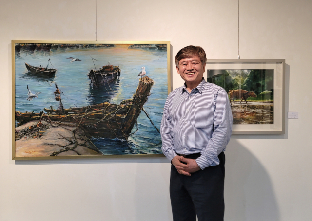 '만선의 꿈'(왼쪽)과 '써레질'을 배경으로 선 김교식 화백 /사진=조상인 미술전문기자