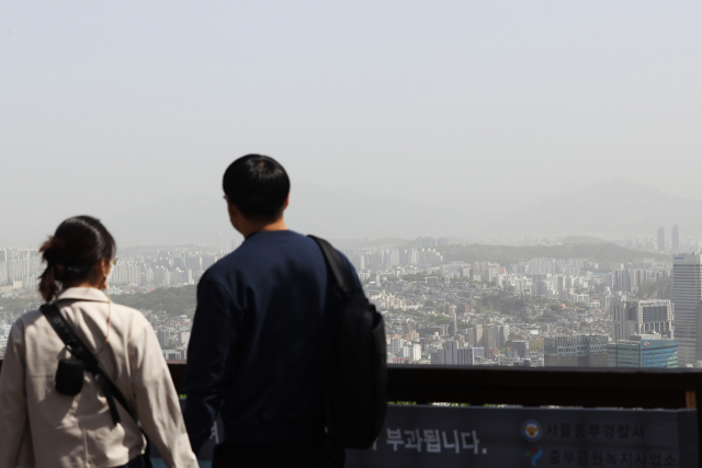 황사가 유입되며 미세먼지 농도가 높아진 27일 서울 남산에서 시민들이 도심을 내려다보고 있다. 연합뉴스