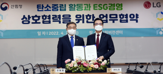 박준성(오른쪽) LG ESG팀장과 최병암 산림청장이 28일 서울 여의도 산림비전센터에서 '탄소 중립 활동과 ESG 경영 상호 협력을 위한 업무협약'을 맺고 있다. 사진 제공=LG