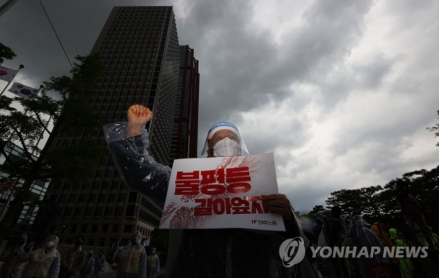 작년 5월 1일 서울 영등포구 여의도 LG트윈타워 앞에서 열린 제131주년 세계노동절대회에서 전국민주노동조합총연맹 조합원들이 '님을 위한 행진곡'을 부르고 있다. 연합뉴스