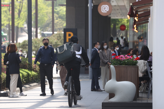 자전거를 탄 배달원이 19일 오후 서울의 한 식당 앞을 지나가고 있다. 연합뉴스