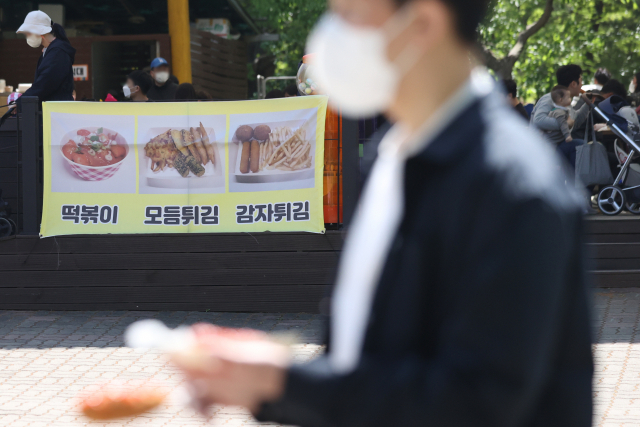 실외 마스크 착용 의무 해제를 하루 앞둔 1일 오후 과천 서울대공원에서 시민이 매점 음식을 사들고 있다. 연합뉴스