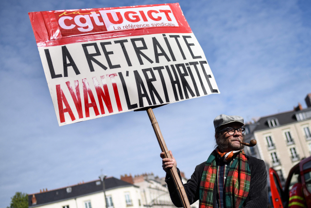 1일(현지 시간) 프랑스 낭트 노동절 집회에서 한 참가자가 ‘관절염 이전에 은퇴’라 적힌 팻말을 들고 있다.AFP연합뉴스