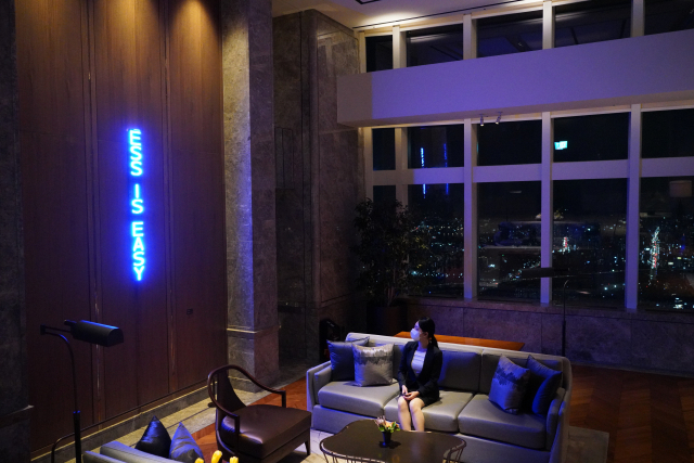 서울 잠실 롯데월드타워 79층의 시그니엘 서울 호텔 로비에 있는 제니 홀저의 '트루 리빙'이 서울 야경을 배경으로 반짝이고 있다.