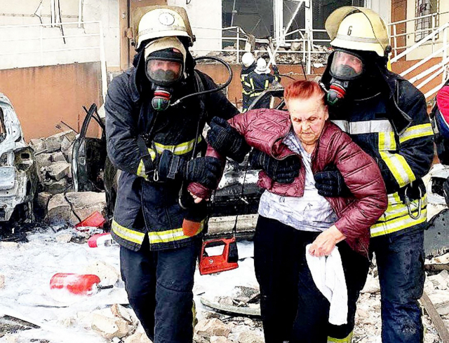 지난달 23일 우크라이나 남부 오데사의 한 건물이 미사일 공격을 받아 구조대원들이 여성 1명을 구조해 탈출하고 있다. AFP연합뉴스