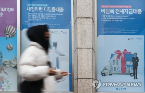한 시민이 지난달 서울 시내 대출 광고가 붙은 은행 앞을 지나고 있다./사진제공=연합뉴스