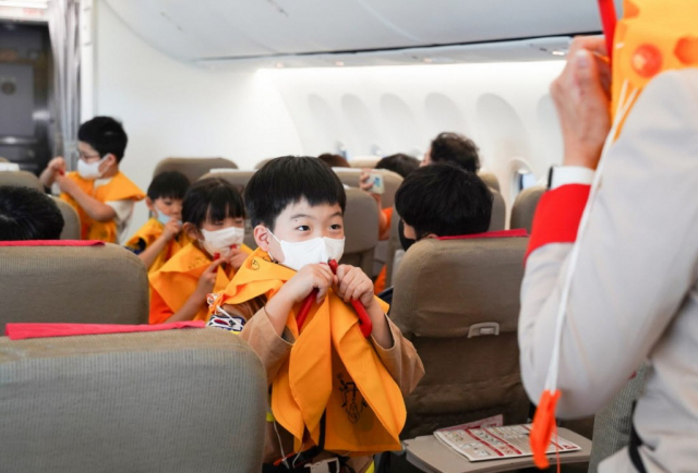 티웨이항공이 지난 3일 김포공항에 위치한 티웨이항공 항공훈련센터에 소방관과 자녀 등 약 40명을 초청해 객실승무원 체험 프로그램을 하고 있다/사진제공=티웨이항공