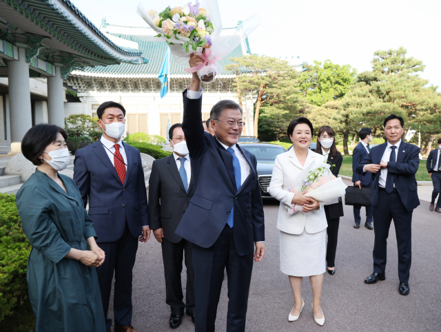 문재인 대통령과 김정숙 여사가 9일 청와대를 떠나기전 직원들로부터 꽃다발을 받고 인사하고 있다./연합뉴스