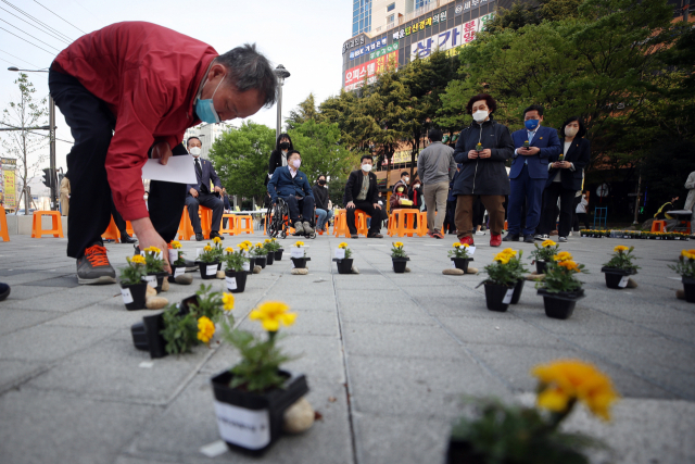 세월호 참사 8주기를 하루 앞둔 지난달 15일 오후 기억 문화제가 열린 광주 남구 백운광장에서 추모객들이 노란 꽃으로 희생자를 추모하고 있다. 연합뉴스