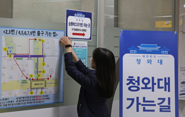 청와대 개방 행사를 하루 앞둔 9일 오후 서울 지하철 광화문역에서 직원이 청와대 순환버스 관련 안내문을 붙이고 있다./연합뉴스