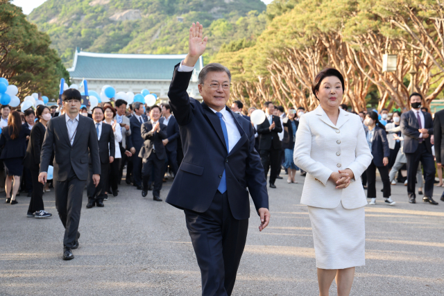 문재인 전 대통령과 김정숙 여사가 지난 9일 오후 청와대 앞 분수대를 지나며 퇴근길 마중 나온 시민들에게 손을 들어 인사하고 있다. 연합뉴스