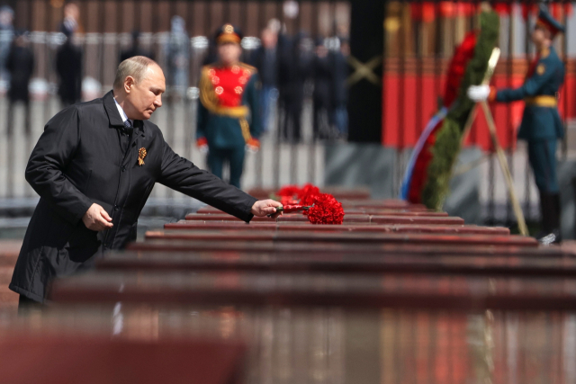블라디미르 푸틴 러시아 대통령이 9일(현지시간) 제2차 세계대전 나치 독일 전승 77주년 기념일을 맞아 크렘린 성벽 옆 모스크바 알렉산더 가든에 있는 영웅도시 기념비에 헌화하고 있다. AFP연합뉴스