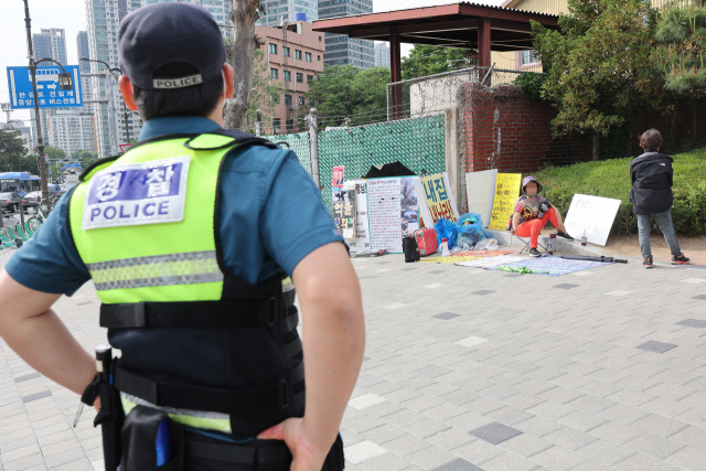 경찰이 11일 서울 용산구 대통령 집무실 인근에서 벌어진 1인 시위 현장을 지켜보고 있다. 연합뉴스