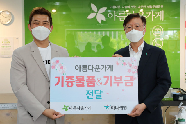이승열(오른쪽) 하나생명 사장이 최수영 아름다운가게 서울사업국장에게 기증 물품과 기부금을 전달하고 있다. 사진 제공=하나생명