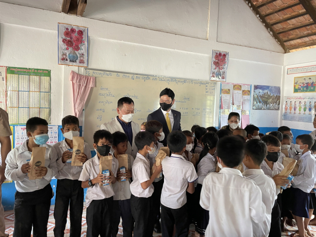 12일 캄보디아 칸달주 꼬레아루 초중등학교에서 열린 '캄보디아 초중등학교 체육시설 개선 및 도서지원' 기부금 전달식이 끝난 뒤 이창권(뒷쪽 가운데) KB국민카드 사장이 현지 아이들에게 간식을 나누어 주고 있다. KB대한특수은행은 지난 2018년 9월 프놈펜에서 가장 작은 은행 중 하나였던 토마토 저축은행을 인수해 출범 이후 1년도 되지 않아 흑자전환에 성공했다. 사진 제공=KB국민카드