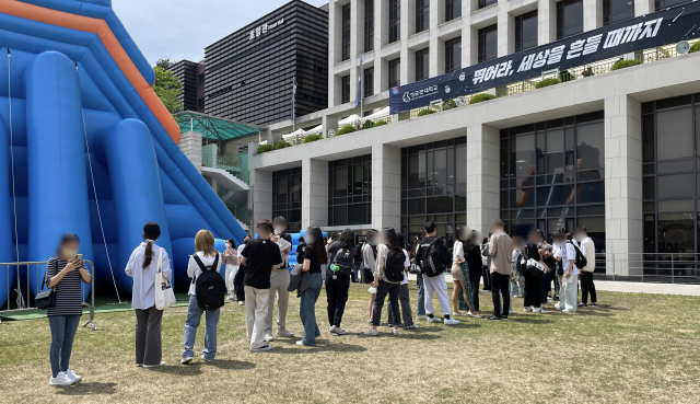 성균관대 학생들이 12일 캠퍼스에 설치된 대형 미끄럼틀을 타기 위해 길게 줄을 서 있다. 박신원 기자