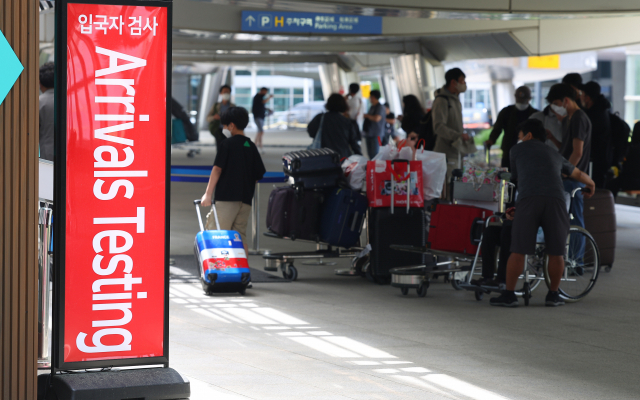 정부가 해외 입국자에 대한 방역 규제 완화 조치를 발표한 13일 오후 인천국제공항 제1여객터미널 청사 외부에 설치된 코로나 센터에서 입국자 대상 검사를 알리는 안내판이 설치돼 있다. 영종도=연합뉴스