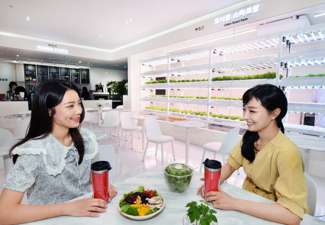 홈플러스 모델들이 16일 서울 마포구 홈플러스 월드컵점에 오픈한 스마트팜 카페 ‘팜스365’에서 직접 재배한 작물로 만든 먹거리를 먹고 있다./사진 제공=홈플러스