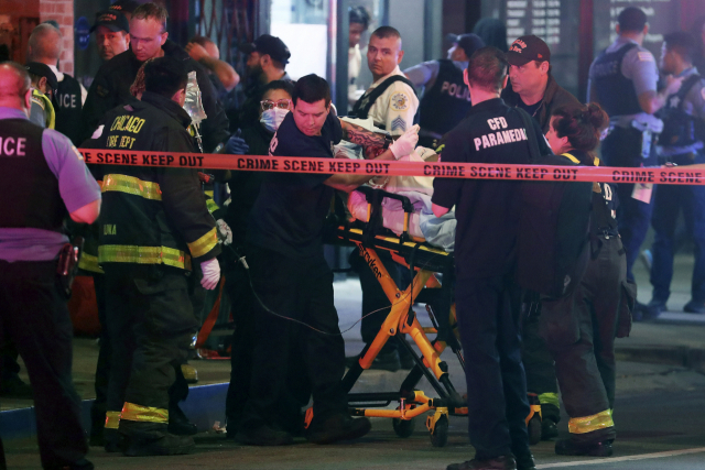 지난 14일(현지시간) 오후 미국 시카고 밀레니엄파크에서 총격사건이 일어나 응급 구조대원이 부상자를 병원으로 이동시키고 있다. AP연합뉴스