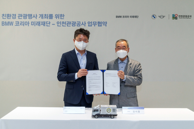 고흥범(왼쪽) BMW 코리아 미래재단 사무국장과 유시경 인천관광공사 본부장이 지난 17일 영종도 BMW 드라이빙센터에서 진행된 협약식에서 친환경 에너지 활용 확대를 위한 업무협약을 체결했다. 사진 제공=BMW코리아 미래재단