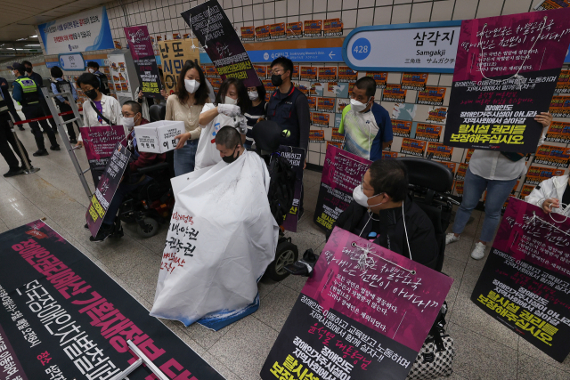 전국장애인차별철폐연대(전장연) 관계자들이 18일 서울 용산구 4호선 삼각지역 승강장에서 장애인권리예산 보장을 촉구하며 삭발시위를 벌이고 있다. 연합뉴스