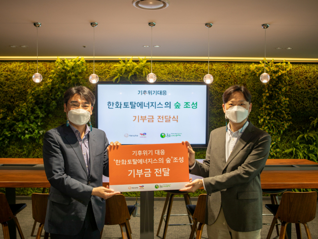 18일 한화토탈에너지스 관계자(오른쪽)가 김종우 사단법인 푸른아시아 실장에게 ‘한화토탈에너지스의 숲’ 조성 기부금을 전달하고 있다. 사진제공=한화토탈에너지스