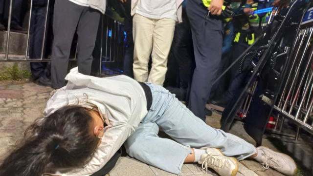 대학생진보연합 일원이 20일 오후 8시 50분께 서울 용산구 하얏트 호텔 인근에서 사전에 신고되지 않은 집회를 개최하려다 경찰에 제압 당해 쓰러져있다. 이건율 기자