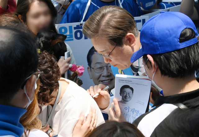 이재명 후보가 20일 인천광역시 계양구 귤현동 일대에서 유세를 하며 한 지지자의 등에 사인을 해주고 있다. /국회사진기자단