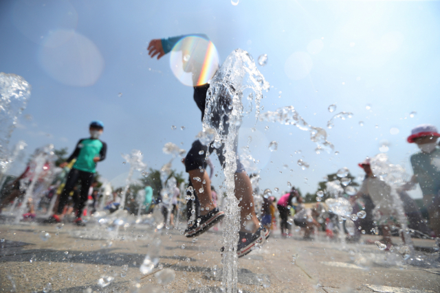 22일 오후 낮 기온이 31도를 웃돈 경북 경산시 삼성현역사문화공원에서 어린이들이 물놀이를 하고 있다. 연합뉴스