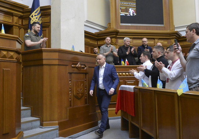 22일(현지시간) 우크라이나 키이우의 국회의사당에서 안제이 두다(가운데) 폴란드 대통령이 연설을 위해 걸어나오자 볼로디미르 젤렌스키(맨 왼쪽) 우크라이나 대통령을 비롯한 현지 의원들이 박수로 환영하고 있다.EPA연합뉴스