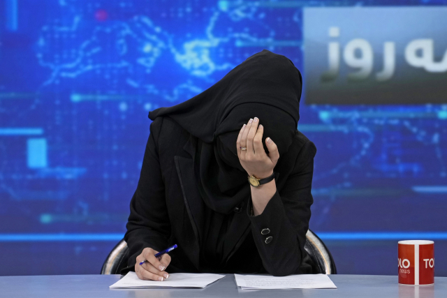 아프간 톨로뉴스 여성 진행자 하테레 아마디가 22일(현지시간) 얼굴을 가리고 뉴스 원고를 읽고 있다. AP연합뉴스