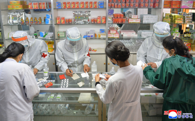 북한 군의부문 요원들이 약국에서 코로나19와 관련 약품을 점검하고 있다./연합뉴스