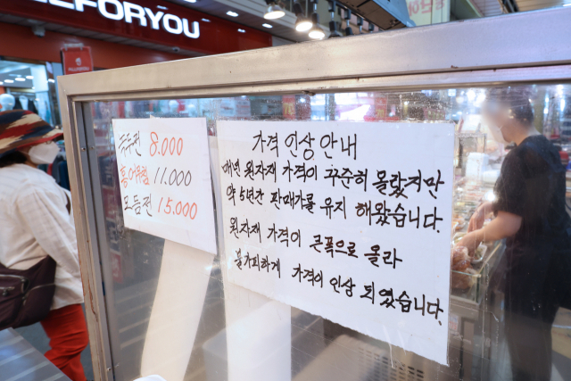 26일 서울 마포구 망원시장의 한 전 가게에 밀가루와 식용유 등 식자재 가격 상승에 따른 가격 인상을 알리는 안내문이 붙어 있다. 연합뉴스