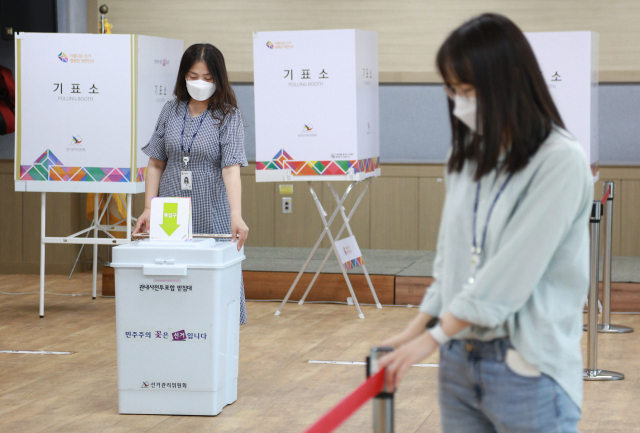 6·1 지방선거 사전투표를 하루 앞둔 26일 대구 동구 효목2동 행정복지센터에 마련된 사전투표소에서 관계자들이 투표소를 최종점검하고 있다. 연합뉴스
