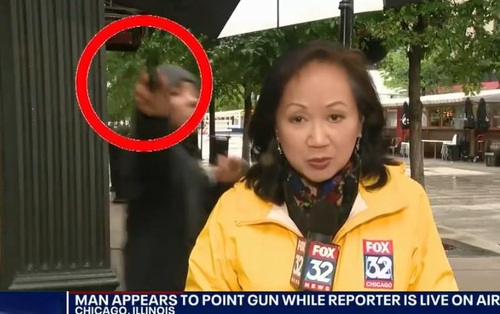 지난 25일(현지시간) '폭스32 시카고' 소속 중국계 중견기자 조니 럼이 ‘총기 폭력 실태’에 대한 뉴스를 전하던 중 한 남성이 카메라를 응시하며 총을 겨누는 장면이 생방송으로 전해졌다. 시카고 폭스뉴스 화면 캡처.