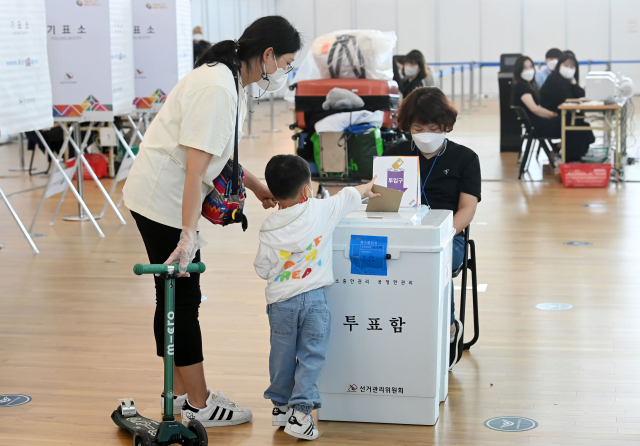 6.1동시지방선거 사전투표일인 27일 인천국제공항에 설치된 사전투표소에서 한 어린이가 엄마와 함께 투표를 하고 있다./영종도=권욱 기자 2022.05.27