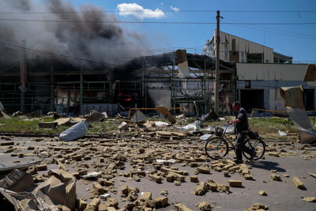 우크라이나 도네츠크 지역의 바크무트에서 한 주민이 27일(현지시간) 러시아의 공격으로 폐허가 된 공장 건물 앞을 지나가고 있다. 로이터연합뉴스