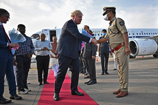 보리스 존슨 영국 총리(가운데)가 지난달 21일(현지시간) 인도 구자라트주 아메다바드공항에 도착한 뒤 영접 나온 현지 경찰 간부와 악수하고 있다. AFP연합뉴스
