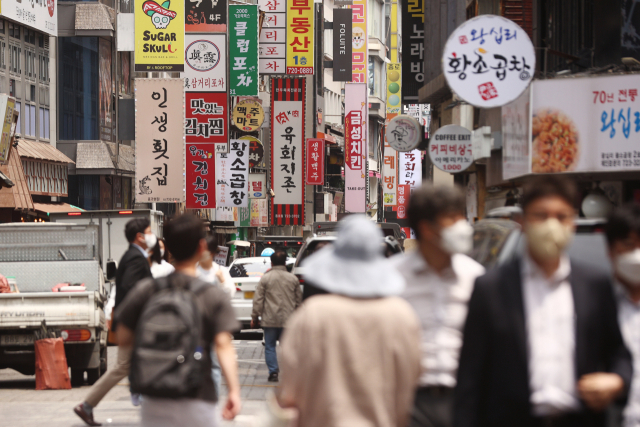 19일 프랜차이즈 가게가 즐비한 서울 시내 먹거리 골목에서 시민들이 걸음을 옮기고 있다. 연합뉴스
