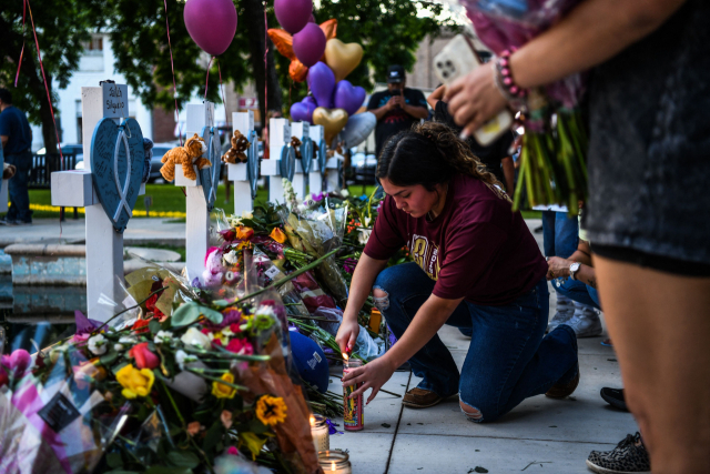 26일(현지시간) 미국 텍사스주 유밸디의 롭 초등학교에서 발생한 총기난사 희생자들의 묘지에서 한 여성이 추모를 위해 촛불을 켜고 있다. AFP연합뉴스