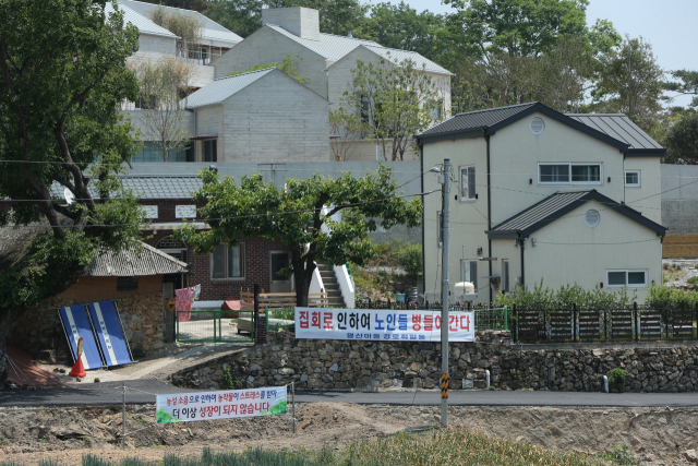 지난 25일 경남 양산시 하북면 지산리 평산마을 문재인 전 대통령 사저 앞에 문 전 대통령 반대단체 집회, 1인 시위에 항의하는 마을주민 현수막이 내걸려 있다. 연합뉴스