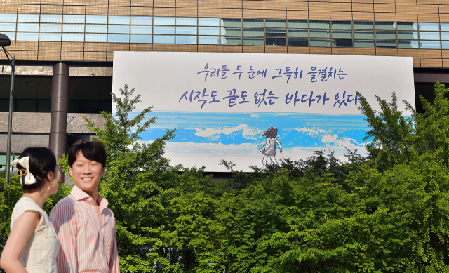 30일 시민들이 교보생명 광화문글판 '여름편'이 내걸린 광화문 교보생명빌딩 주변을 걷고 있다. 이번 문안은 올해로 탄생 100주년을 맞은 김춘수 시인의 시 '능금'에서 가져왔다. 바다가 스스로 파도를 일으키듯이 저마다 내면의 힘과 무궁무진한 가능성이 있음을 되새기자는 의미를 담았다. 사진 제공=교보생명